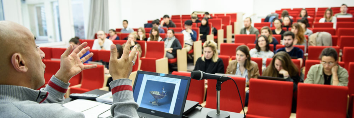 Quel Mastere en patrimoine est fait pour toi ? Etudiants écoutant un professeur dans un amphithéâtre